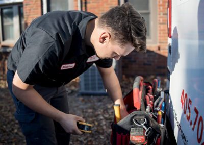 a man wearing a black shirt, standing next to a white truck